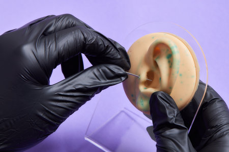 Professional placing the jewel of training silicone for ear piercing Tragus type.