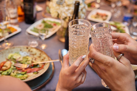 Celebrating with glasses of alcohol in hands. Happy female friends having good time.の写真素材