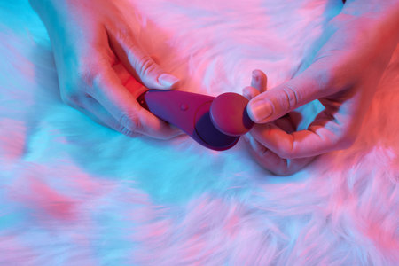 desire concept : Woman lying in bed holding a dildo vibrator in her hand to help herself.の写真素材