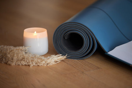 Yoga mat and burning candles on floor.の写真素材