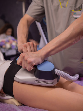 The procedure of myostimulation on the legs and buttocks of a woman in a beauty salon. Caring for...