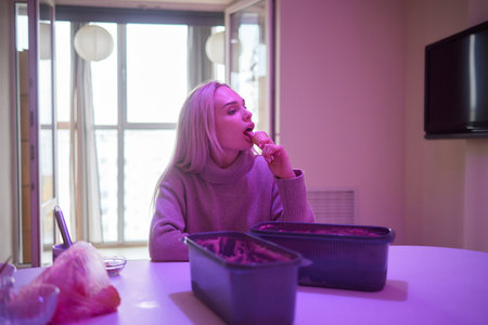 Smiling girl eating an ice-cream hands putting ice cream balls in waffle cone.の写真素材