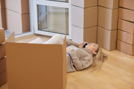 Young woman moving new place and repair concept - happy young woman with many cardboard boxes...