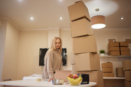 Young happy American woman with stack of cardboard boxes.の写真素材