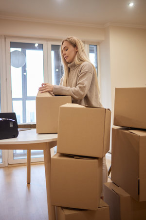 Young happy American woman with stack of cardboard boxes.