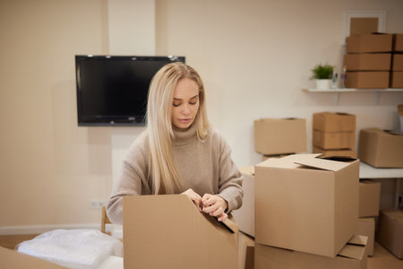Young happy American woman with stack of cardboard boxes.