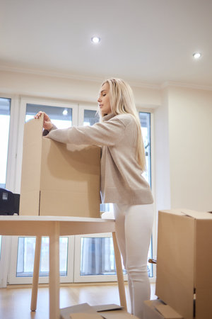 young blonde woman barcode printer and boxes on the background for market places.