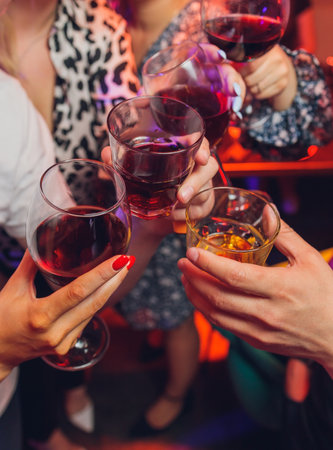 Clinking glasses with alcohol and toasting, party.の写真素材