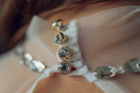 Charming bridesmaid dress with a delicate bow, rhinestones, embroidery and shiny beads close-up.
