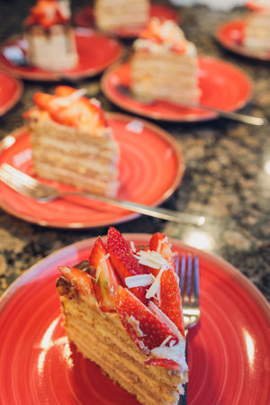 Strawberry Cake In a red plate and eaten on a wooden table.