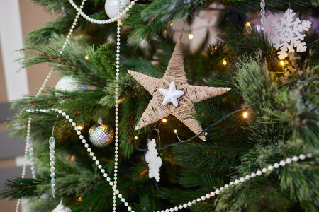 Lit with garland deer in front of decorated artificial christmas tree with whitened ends. Bow tied...