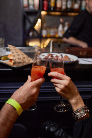 Clinking glasses with alcohol and toasting, party.