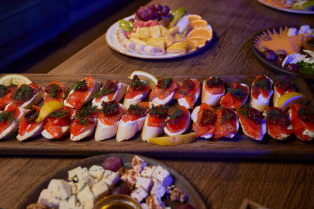 Banquet table with snacks, food on plates, festive table, corporate foodの写真素材