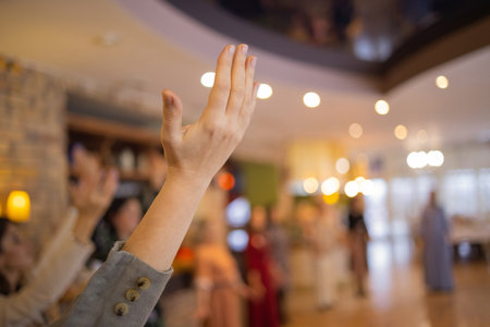 Woman putting hands up and dancing. Excited young female celebrating a victory. Muslim woman in traditional Islamic clothing - hijab. Birthday, New Year celebration concept.の写真素材