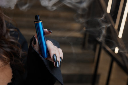 disposable electronic cigarettes in hand. The concept of modern smoking, vaping and nicotine.