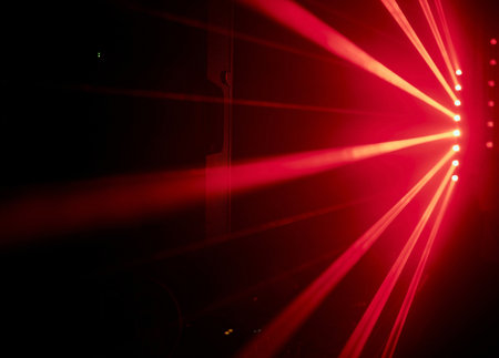 Bright red neon laser lights illuminate the darkness creating lines and triangle shapes in sci-fi effect.の写真素材