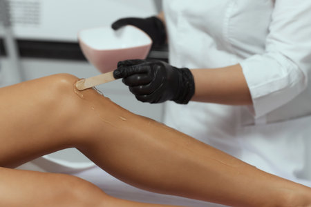 Young African woman getting laser hair removal on her thighs.の写真素材