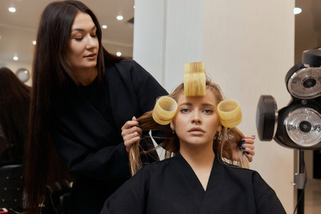 Drying blond hair with hair dryer and round brush.の写真素材