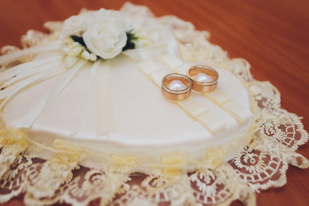 Gold wedding rings on a small pillow close-up.の写真素材