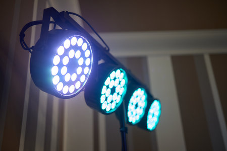 Installation of professional sound, light, video and stage equipment for a concert. Stage lighting equipment is clamped on a truss for lifting. Flight cases with cables.の写真素材