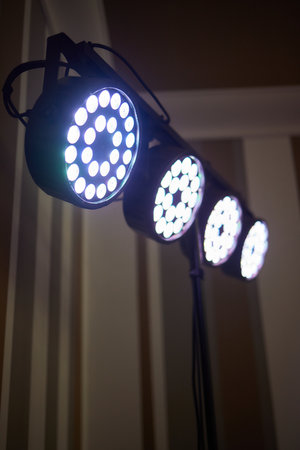 Installation of professional sound, light, video and stage equipment for a concert. Stage lighting equipment is clamped on a truss for lifting. Flight cases with cables.の写真素材