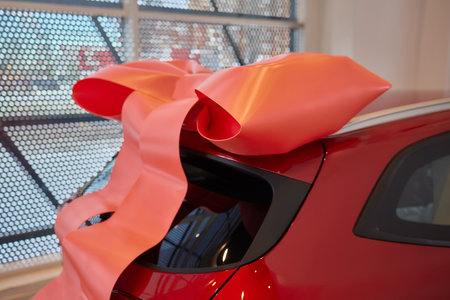 The new car is wrapped in a red bow. Beautiful gift concept.の写真素材