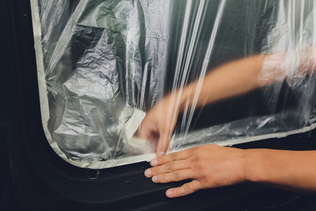 Mechanic preparing a car for painting by protecting the edges.の写真素材