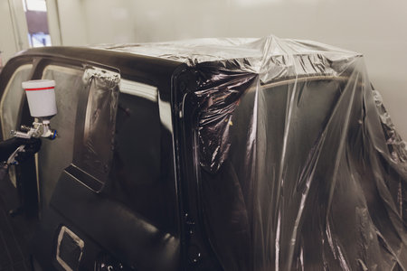 Worker painting a car in a paint booth,の写真素材