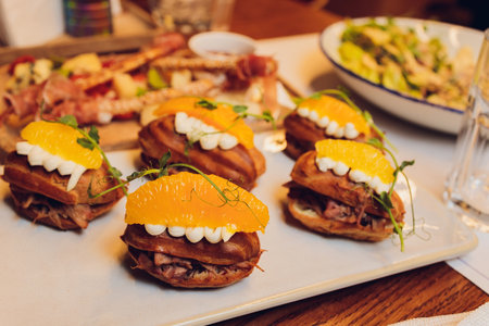 Meat on sliced baguette. Small sandwiches on board. Tasty meal at italian cafe. Proven recipe of bruschetta.の写真素材