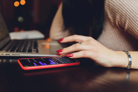 Woman hands typing on laptop, tablet and red wine outdoors in cafe.の写真素材