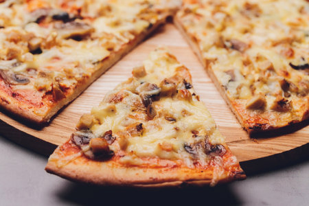 Slices of pizza on rustic wooden tray and dark background.の写真素材