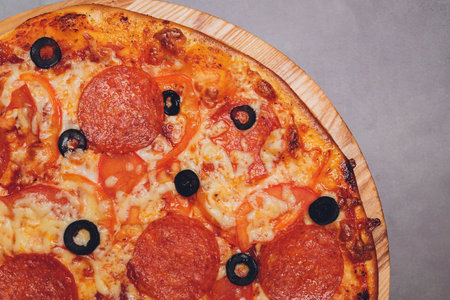 Pizza pepperoni, mozzarella, oregano on a black background.