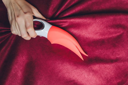 Woman in bedroom holding vibrator in hand.の写真素材