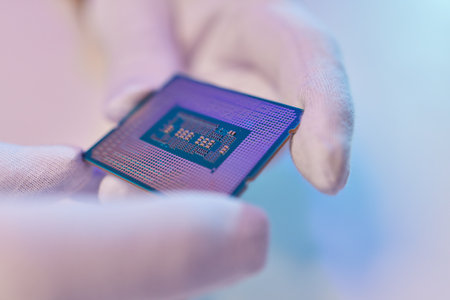 Hand in white glove holding a CPU computer processor microchip.
