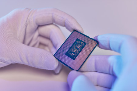 Hand in white glove holding a CPU computer processor microchip.の写真素材