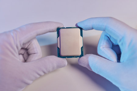 Hand in white glove holding a CPU computer processor microchip.の写真素材