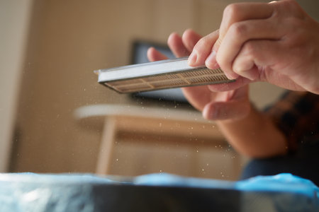 Cleaning the filter of the vacuum robot cleaner from dirt, close-up.の写真素材