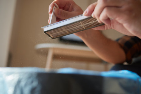 Cleaning the filter of the vacuum robot cleaner from dirt, close-up.の写真素材