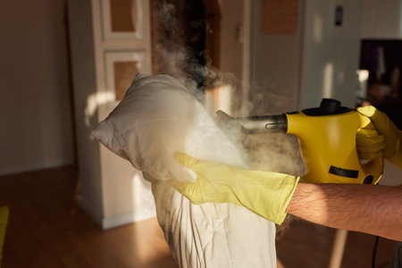 man steaming pillow at home, closeup view.