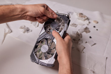 Changing the thermal paste on the graphics processor. Disassembled graphics card on the table. Old...