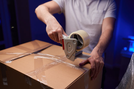young man packing a monitor in a cardboard box.