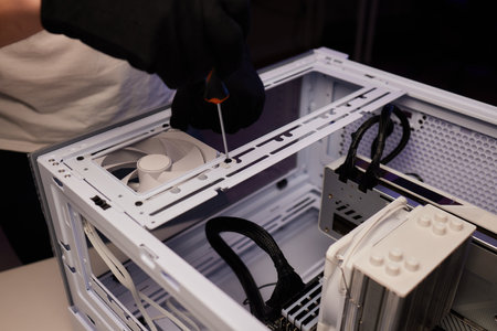 A computer technician assembles a desktop computer with new parts. Upgrading or replacing PC parts.