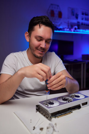 Changing the thermal paste on the graphics processor. Disassembled graphics card on the table. Old graphics card service.の写真素材