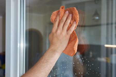 Woman cleaning window at home, closeup. Household chores.