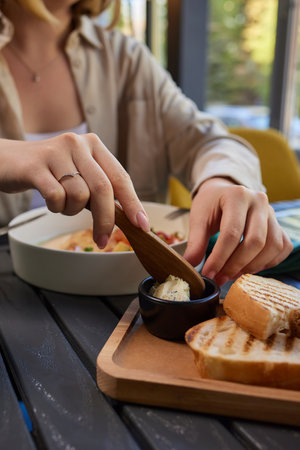 Healthy breakfast. happy young woman preparing tasty snacks at the kitchen table in the morning light.の写真素材