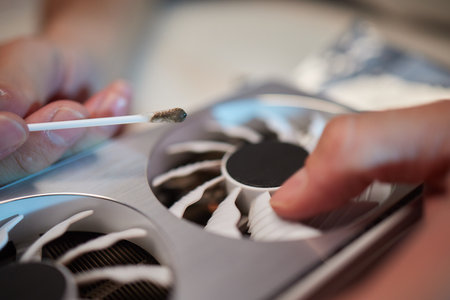 Changing the thermal paste on the graphics processor. Disassembled graphics card on the table. Old...