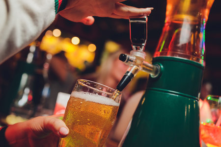 Barman pours beer into glasses for its tasting.