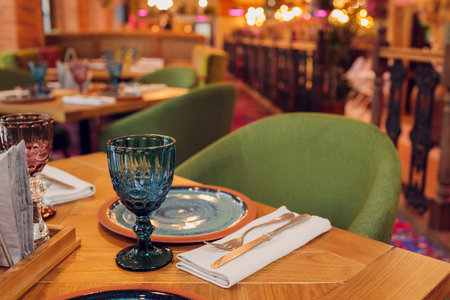 two beautiful glasses of glass stand on the table with a plate in the red interior.