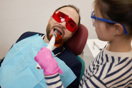A small curly girl and her father play a dentist. happy relationship.の写真素材