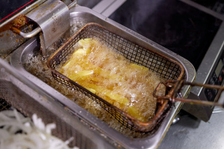 Dirty cooking area with french fries deep fryer.